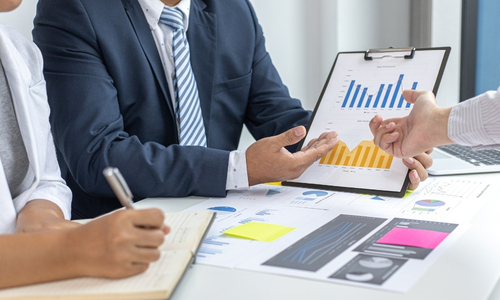 Business meeting analyzing charts and graphs data.